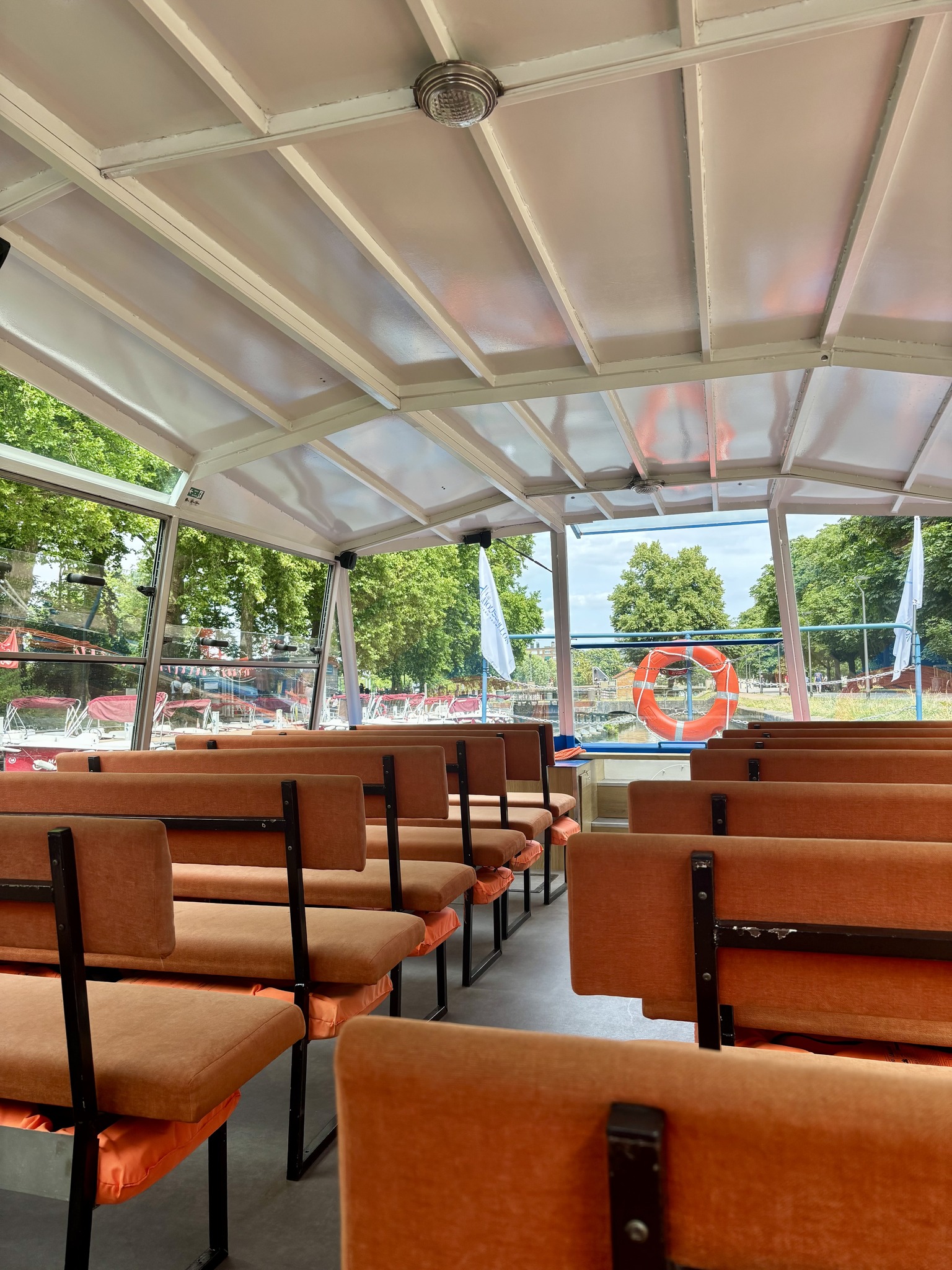 Banquettes et grandes fenêtres à l’intérieur du bateau Le Moussaillon à Lille.