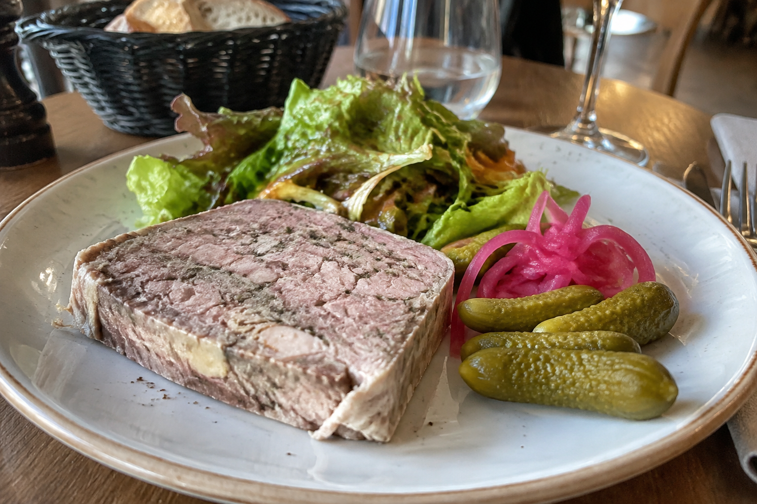 Terrine de campagne « Maison », accompagnée de cornichons, de pickles d’oignons et d’une salade croquante.